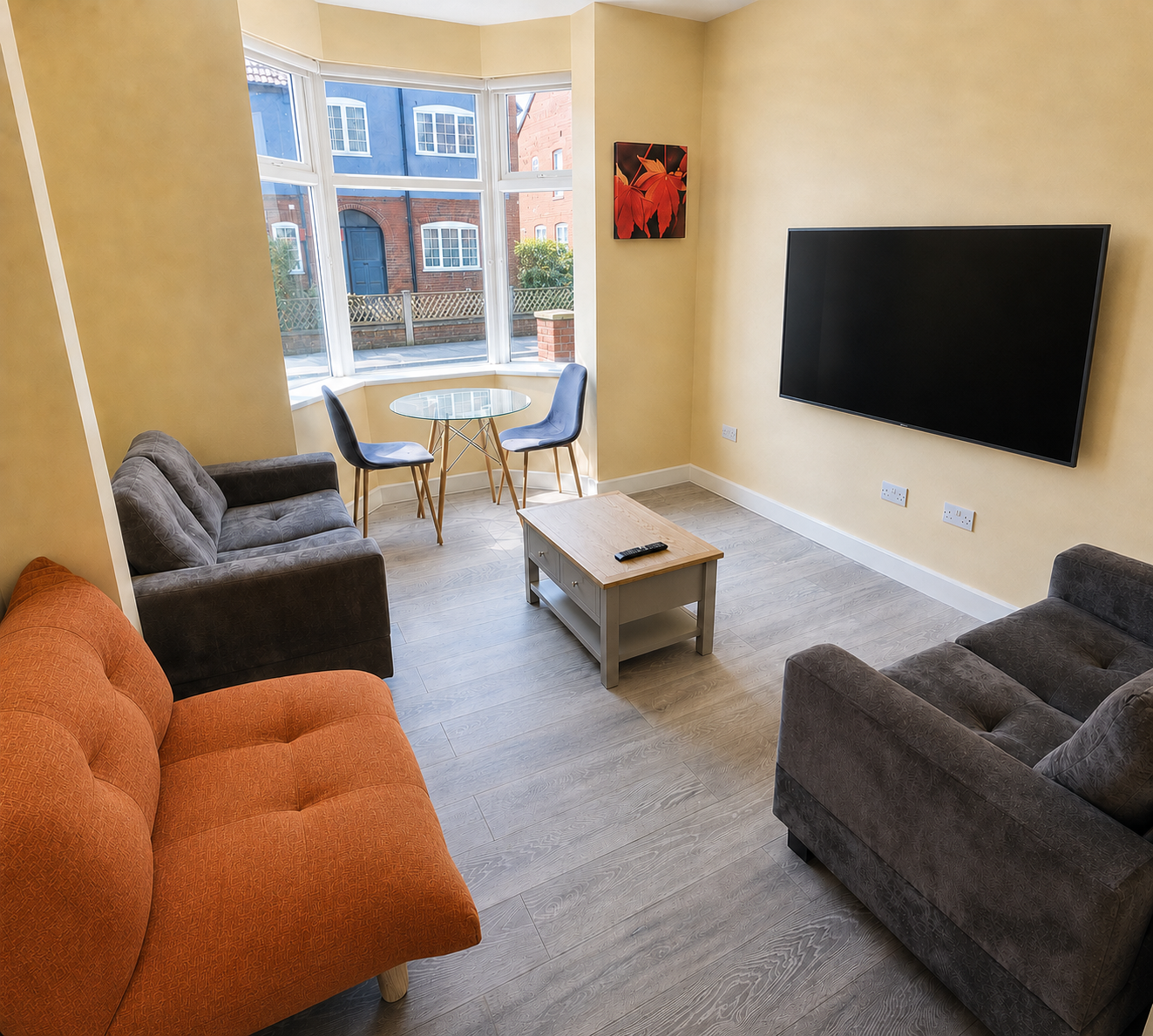 Communal lounge with seating, dining space and a wall-mounted television.